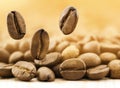 Flying fresh coffee beans on yellow blurred background with copy space. Coffee beans falling down Royalty Free Stock Photo