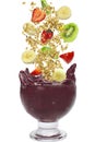 Flying fruits falling in a cup of acai