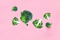 Flying green broccoli slices on a pink background. Royalty Free Stock Photo