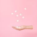 Flying hand and sugar cubes levitation on pink Minimal or surrealism style.