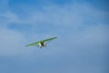 A flying hang-glider on the background of a blue sky