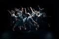 Flying high. Group of young artistic people making freestyle performance, dancing against black studio background Royalty Free Stock Photo