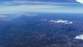 Flying high view from brown mountains through the plain Spain with some clouds view from an airplane window Royalty Free Stock Photo