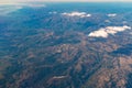 Flying high view from brown mountains through the plain Spain with some clouds view from an airplane window Royalty Free Stock Photo