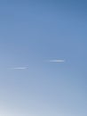 Flying jet with white smoke streams in a blue sky Royalty Free Stock Photo