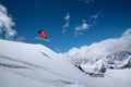 Flying in a jump over a slope Freestyle skier jumping in an orange ski suit in the snowy mountains on a sunny day Royalty Free Stock Photo