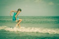 Flying jumping beach girl at blue sea shore