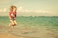 Flying jumping beach girl at blue sea shore