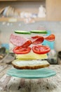Flying layers of sandwich with ham, cheese, and vegetables over the grunge wooden table. Breakfast food concept Royalty Free Stock Photo
