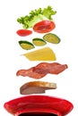 Flying layers of sandwich; ham; cheese; vegetables and red plate Royalty Free Stock Photo