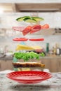 Flying layers of sandwich; ham; cheese; vegetables and red plate over the wooden table. Breakfast food concept Royalty Free Stock Photo