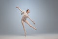 Young and graceful ballet dancer, ballerina dancing in image of angel with wings on gray studio background. Art