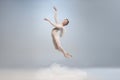 Young and graceful ballet dancer, ballerina dancing in image of angel with wings on gray studio background. Art