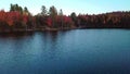 Flying low over the lake towards the colorful trees in Autumn in the Laurentians