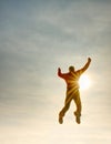 Flying man. Silhouette of jumping man and sunset sky. Sun flare Royalty Free Stock Photo