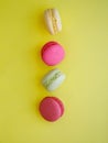 flying multi-colored assorted bright macarons close-up on yellow background