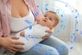 Flying music notes and young woman with her baby at home, closeup. Lullaby songs