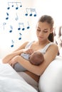 Flying music notes and woman with her baby at home. Lullaby songs Royalty Free Stock Photo