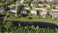 Flying over an American suburban neighborhood houses in USA with drainage ponds. 4K