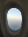 Flying over clouds, a plane window with a view over clouds Royalty Free Stock Photo