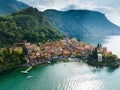 Flying over colorful houses of Varenna village on Lake Como, Italy. Aerial shot of old town Varenna on the coast of Lake Royalty Free Stock Photo