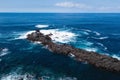 Flying over the ocean surf on the reefs coast of San Miguel island, Azores