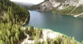 Flying over Pine Trees and white beaches, over beautiful Lake Prags. Aerial 4K