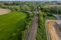 aerial drone shot of a railroad in between rural fields and vegetation Royalty Free Stock Photo