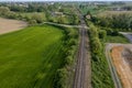 aerial drone shot of a railroad in between rural fields and vegetation Royalty Free Stock Photo