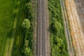 aerial drone shot of a railroad in between rural fields and vegetation Royalty Free Stock Photo