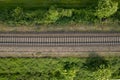 aerial drone shot of a railroad in between rural fields and vegetation Royalty Free Stock Photo