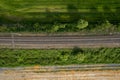 aerial drone shot of a railroad in between rural fields and vegetation Royalty Free Stock Photo