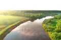 Flying over river and green forest at summer sunny day, sky reflecting in water. Royalty Free Stock Photo