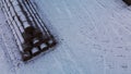 Flying over a snowy field. Straw bales are stacked. Traces of agricultural tillage are visible under the snow. Aerial photography