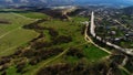 Flying over stunning cityscape and green summer landscape. Shot. Aerial view of curving wide and narrow roads and paths
