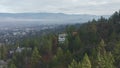 Flying Over Trees and Houses in a Hill With Majestic Mountains as Background