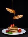 Flying pancakes with honey and strawberries. Royalty Free Stock Photo