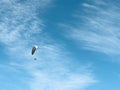 Flying paraglider on a background of bright blue sky with soft clouds