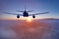 Flying of the passenger plane above the clouds and mountains Royalty Free Stock Photo