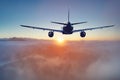 Flying of the passenger plane above the clouds and mountains Royalty Free Stock Photo