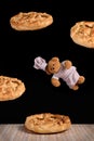 Flying pastry chef Teddy bear and apple pies on black background Royalty Free Stock Photo