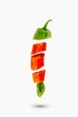 Flying pieces of red and green hot chili peppers on a white background. Isolated Royalty Free Stock Photo