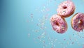 Flying pink sprinkled donuts. Sweet doughnut on pastel blue background