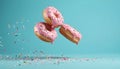 Flying pink sprinkled donuts. Sweet doughnut on pastel blue background