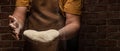 Flying pizza dough with flour scattering in a freeze motion of a cloud of flour midair on black. Cook hands kneading dough. copy Royalty Free Stock Photo