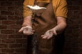 Flying pizza dough with flour scattering in a freeze motion of a cloud of flour midair on black. Cook hands kneading dough. copy Royalty Free Stock Photo