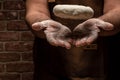 Flying pizza dough with flour scattering in a freeze motion of a cloud of flour midair on black. Cook hands kneading dough. copy Royalty Free Stock Photo