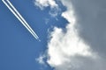 Flying plane in the blue sky approaching the clouds