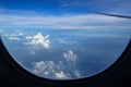 Flying on the plane seeing sunrise light on abstract white cloud and shades of blue sky background with airplane wing Royalty Free Stock Photo