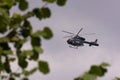 Flying police helicopter G-16 against cloudy sky Royalty Free Stock Photo